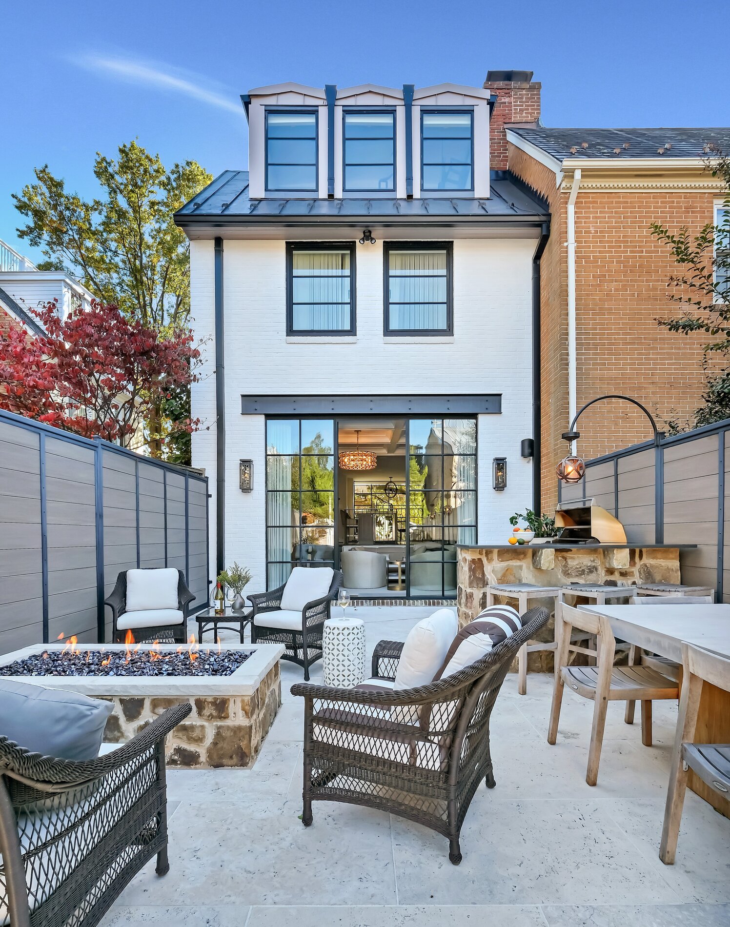 A backyard featuring patio furniture arranged around a cozy fire pit, ideal for outdoor gatherings.